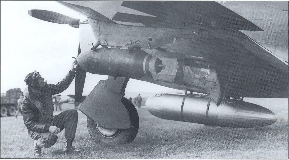 Un pilota ispeziona l'equipaggiamento del suo P-47 Thunderbolt, prima del decollo. Oltre alle bombe da 500 libbre fissate sotto le ali, si nota il serbatoio sganciabile 108-gallon agganciato direttamente sul ventre dell'aereo.
